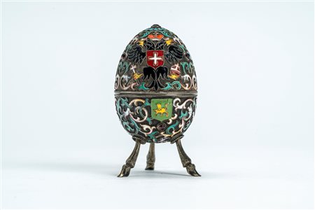 Uovo in argento dorato con smalti policromi cloisonné e cabochon, coperchio apribile decorato con aquila bicipite coronata con scettro e globo e picco […]