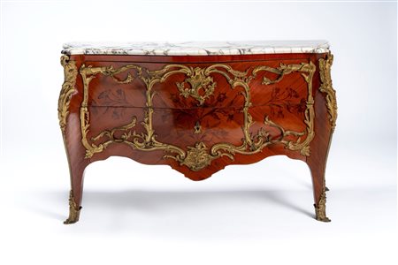 Commode di gusto francese Luigi XV di forma mossa e bombata impiallacciata e intarsiata a motivi floreali con ricche applicazioni in bronzo, fronte a  […]