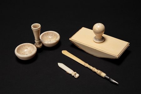 ☼ Set da scrittura in avorio composto da calamaio, penna tornita ed intagliata con impugnatura piatta e pennino in metallo, tampone e segnalibro con f […]