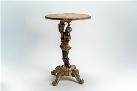 Tavolino in legno intagliato e decorato in policromia, con piani mossi terminanti a ricciolo e piano sagomato; fusto a guisa di moretto reggente cornu […]