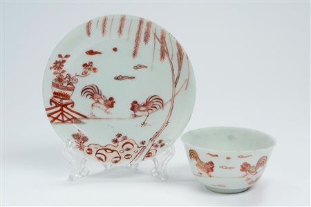 Tazzina con piattino in porcellana decorata in rosso ferro e oro a galli. Cina, secolo XVIII