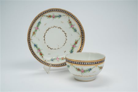 Tazzina con piattino in porcellana con decoro policromo a festoni e dorature. Manifattura di Nyon, 1770 circa