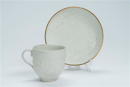 Tazza con piattino in porcellana bianca a rilievo. Inghilterra, manifattura di Derby, fine secolo XVIII
