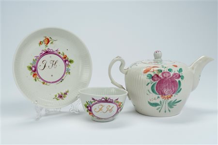 Lotto composto da una tazzina con piattino in porcellana decorata in policromia con monogramma in un cartiglio color porpora ed una teiera con decoro  […]