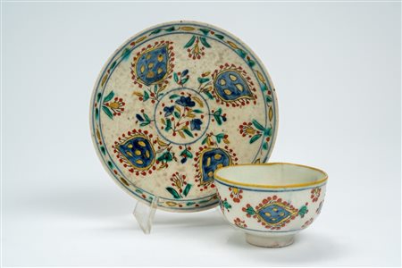 Fincan con piattino in maiolica a smalto stannifero decorato in policromia. Turchia ottomana, Kütahya, fine secolo XVIII/inizio secolo XIX