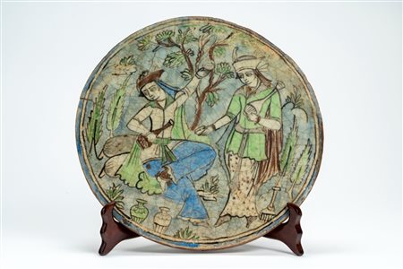 Grande placca in terraglia smaltata con scena conviviale qajar in un giardino. Persia, fine secolo XIX/XX