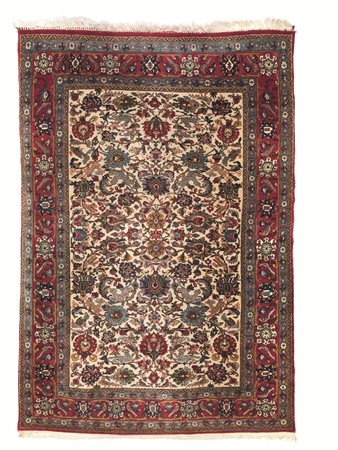 TAPPETO PERSIANO QUM, INIZI SECOLO XXfondo avorio con decori floreali verdi e...