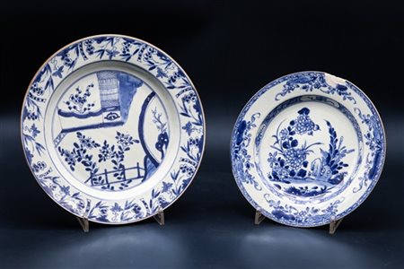 Duie piatti in porcellana bianca e blu con decoro floreale e a pagode. 
Cina, d