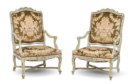 Coppia di poltrone in legno intagliato e laccato di forma sagomata con grembial