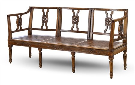 Divano a tre posti in noce intagliato con schienale traforato. Seduta in paglia