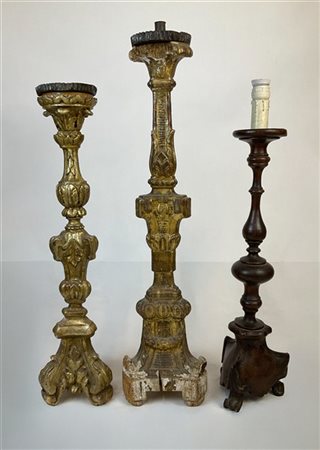 Lotto composto da tre diversi antichi candelieri in legno tornito e intagliato,
