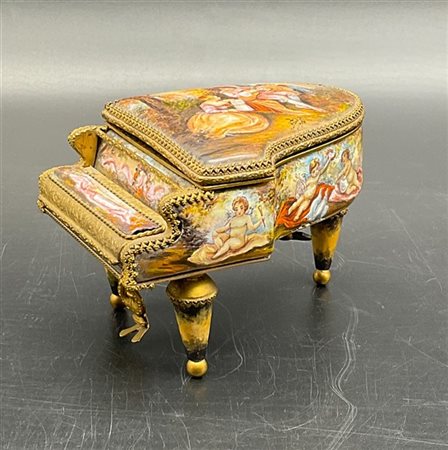 Scatola musicale in metallo dorato e smalti policromi a forma di pianoforte a c