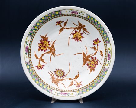 Grande piatto in porcellana dipinta in policromia, fiori sparsi nel cavetto e f