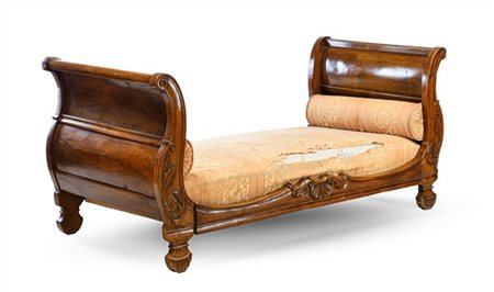 Letto a barca in noce intagliato con fronte decorato da volute fogliacee. Secol