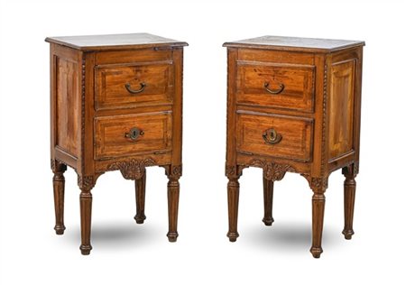 Coppia di comodini a un cassetto e un'anta in legni vari in parte intagliati e
