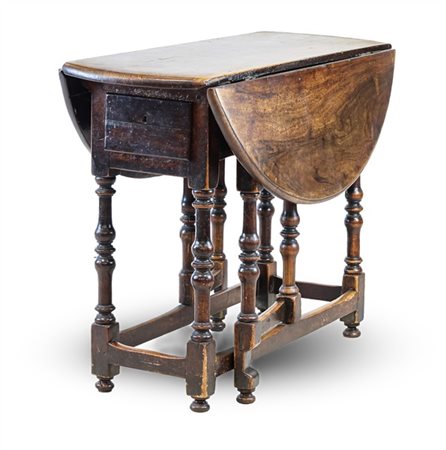 Tavolo tondo a bandelle in legni vari, con cassetto, gambe tornite riunite da t