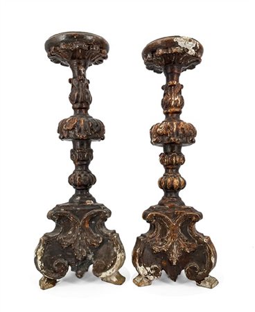 Coppia di candelieri in legno intagliato con fusto tornito decorato a volute fo