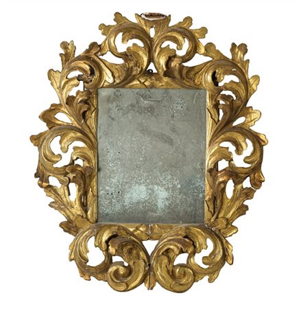 Piccola specchiera con cornice in legno intagliato e dorato a motivi fogliacei.