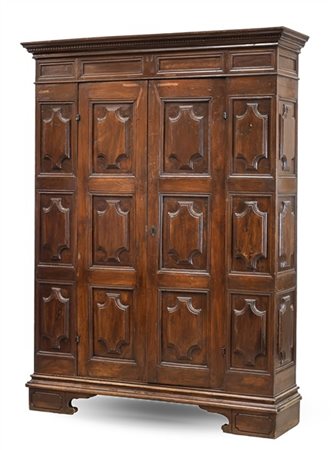 Armadio a due ante in noce con piedi a mensola, cimasa con profilo dentellato (