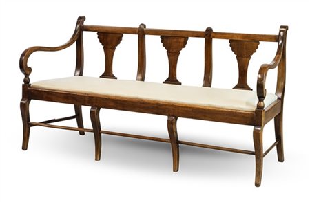 Divano di forma sagomata in noce con schienale a cartelle sagomate e braccioli