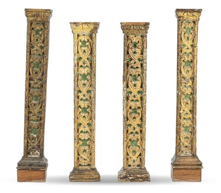 Gruppo di quattro paraste in legno intagliato a motivi fogliacei, laccate e dor