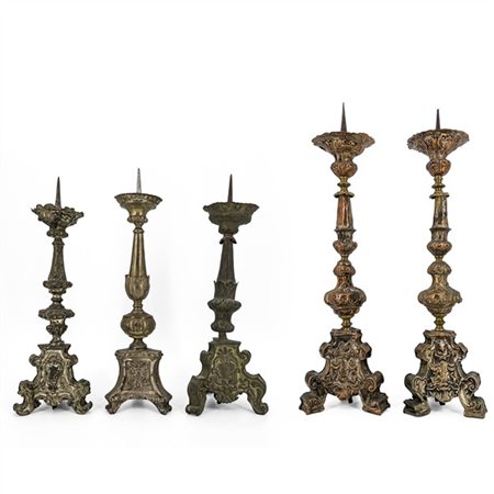 Lotto di cinque diversi candelieri in legno rivestito in metallo argentato inci