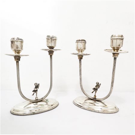 Coppia di candelabri a due fiamme in argento 800 con puttino sulla base