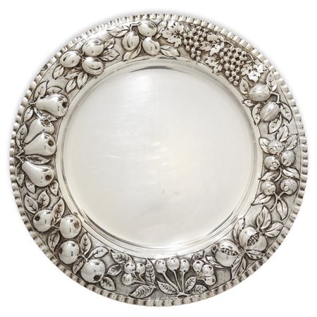 Piatto centrotavola in argento 800 con decorazioni a sbalzo di melagrane lungo il bordo lungo il bordo