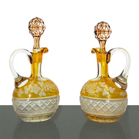 Coppia di bottiglie in cristallo di Boemia colorato nei toni del giallo bulinato a tralci d'uva e smerigliato alla base