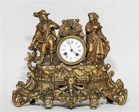 OROLOGIO DA MENSOLA IN METALLO DORATO sormontato da un gruppo raffigurante...