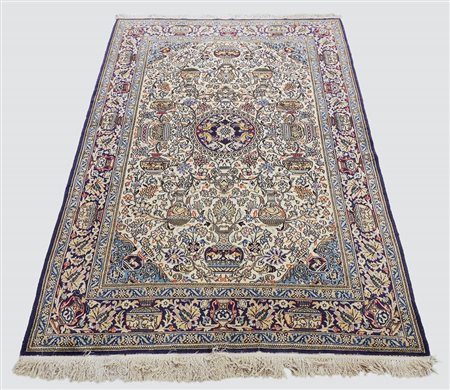 TAPPETO PERSIANO fondo avorio, campo con motivi vegetali e vasi, medaglione...