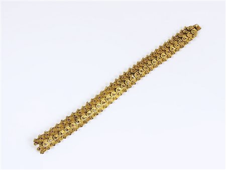 BRACCIALE IN ORO GIALLO E RUBINI Anni Sessanta realizzato con maglie a squame...