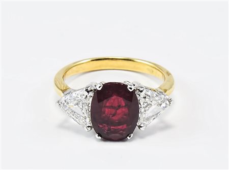 ANELLO IN ORO, RUBINO E DIAMANTI centrato da rubino ovale affiancato da due...