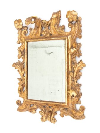  
Specchiera in legno intagliato e dorato Italia centrale, XVIII secolo
 Altezza x larghezza x profondità: 93 x 77 x 12 cm.