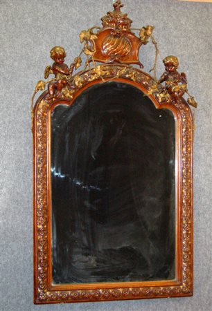 Specchiera in pastiglia tinta legno rifinita in oro con cimasa a guisa di...