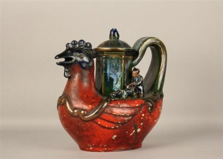 Teiera in ceramica smaltata a forma di gallo con due figure di bambini....