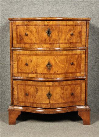 Comodino fronte mosso in legno di noce, tre cassetti lastronati in radica e...