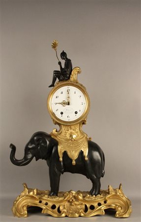 Orologio in bronzo dorato e patinato a guisa di personaggio con elefante....