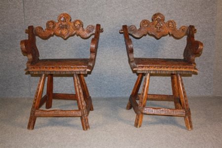 Due poltrone in legno di noce intagliato, sullo schienale stemmi nobiliari e...