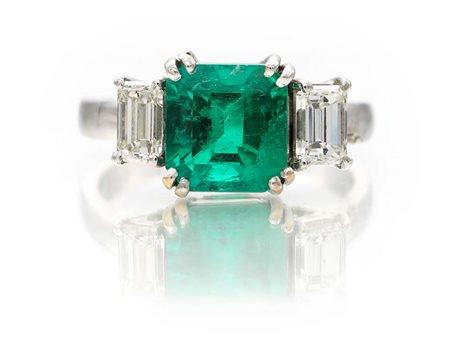 Anello con smeraldo colombiano in taglio smeraldo e baguettes. Oro bianco...