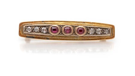 Spilla in oro, argento, 3 rubini e diamanti Oro giallo 750/000. Peso...
