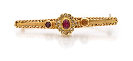 Spilla in oro, pietre rosse e diamanti Oro giallo 750/000. Peso complessivo...