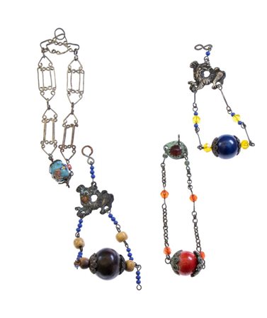  Loro di 4 amuleti in argento, legno e paste vitree