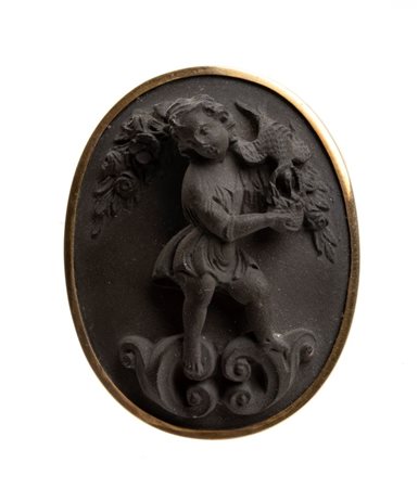  
Spilla in oro con cameo in pietra lavica  Italia, XIX secolo
 Altezza x larghezza x profondità: 4,5 x 3,5 x 2 cm.