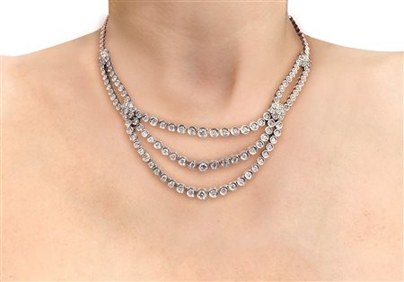 Collier in oro bianco 18 kt a tre file di diamanti taglio brillante con decorazioni a guisa di fiore.
