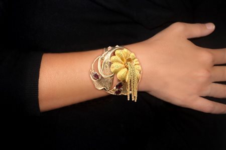 Bracciale in oro basso titolo con decoro a guisa di fiore con granati e filigrana