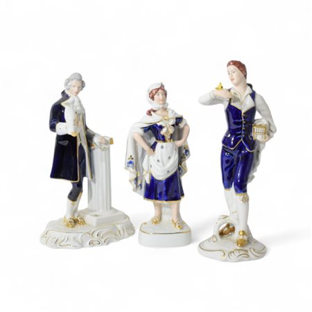 Tre grandi statuette di personaggi in abiti del Settecento in porcellana...