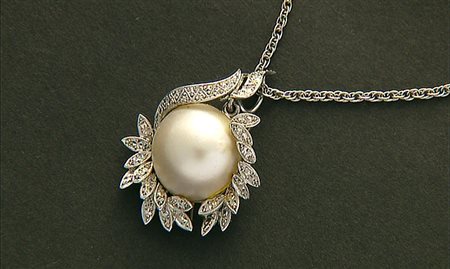 CIONDOLO CIONDOLO. In oro bianco 18 kt centrato da perla mabè entro cornice...