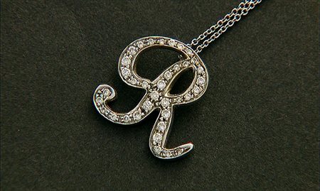 CIONDOLO CIONDOLO. In oro bianco 18 kt raffigurante lettera "R" decorata da...