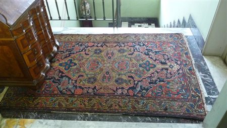 TAPPETO PERSIANO fondo rosso ciliegia, campo con motivi floreali nei toni del...